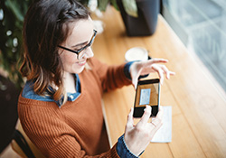 Woman scanning check with cellphone