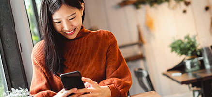 young smiling woman looking at mobile phone