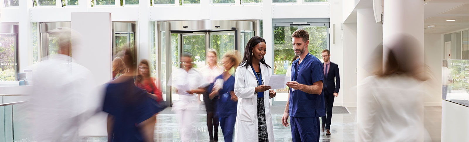 two doctors talking in busy medical office