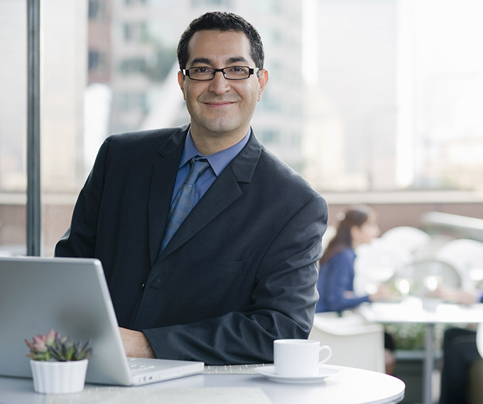 man in suit and tie at cafe with laptop