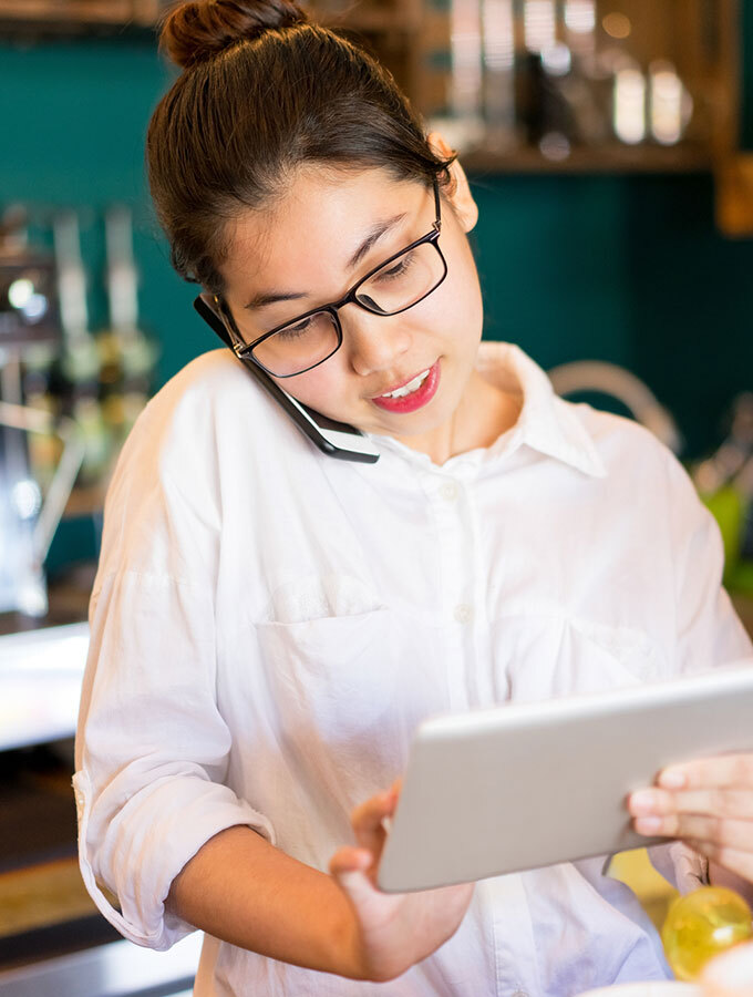 Women on phone & tablet in a cafe