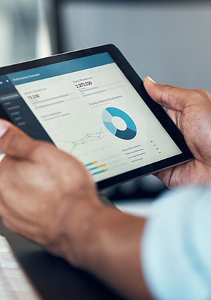 Man holding tablet with charts.